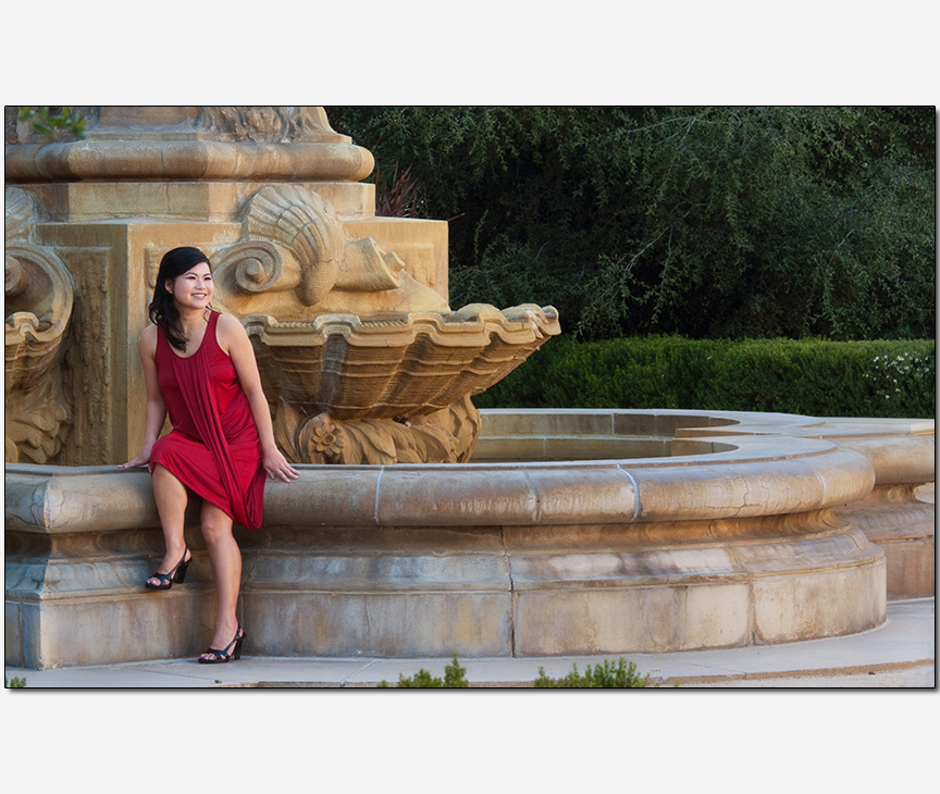 Asian-American woman posing on a fountain